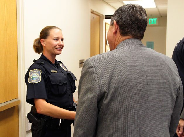 Officer Jenn Gravel is congratulated by Mayor Bob Severns for her role in helping a domestic violence victim recently.