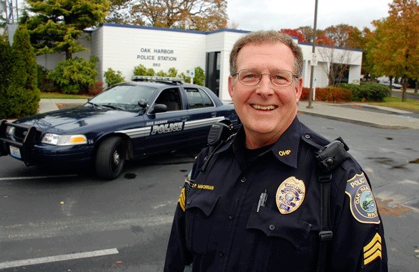 Oak Harbor Police Sgt. Sean Magorrian stands in front of his 2008 patrol car. He is retiring at the end of the month after more than 30 years in the department.