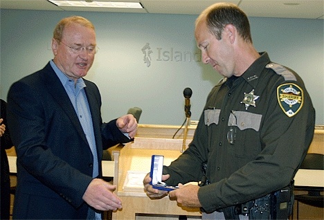 Island County Sheriff’s Deputy Dan Todd examines the Life Saving Medal he was awarded for his efforts saving the life of a man who attempted suicide in November.
