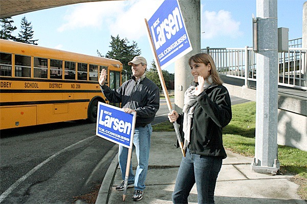 U.S. Rep. Rick Larsen(left) enjoys last-minute campaigning Tuesday at the corner of Highway 20 and Main Street in Coupeville. He stopped in Clinton