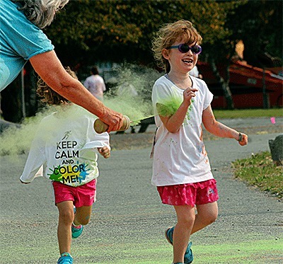 A youngster gets doused at the first color station during the kids dash of the Run IN Color Saturday.