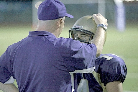 Quarterback Clarence Lamont listens to advice from offensive coordinator Mike Fisher.  Lamont passed for 145 yards and two touchdowns in Oak Harbor’s win Friday.