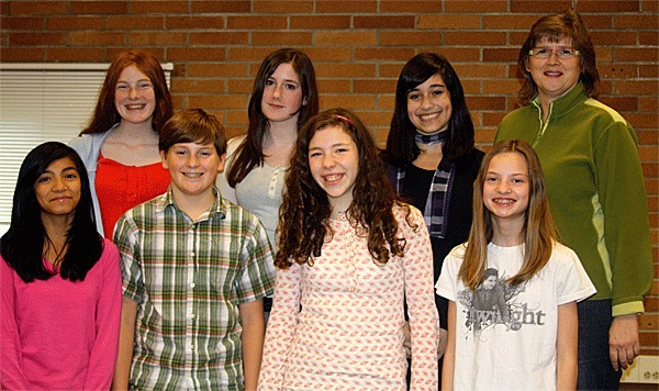 Oak Harbor Middle School choir students stand on the risers in performance formation in their classroom. From top left