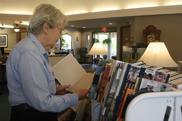 Lou Biddle looks through a selection of books brought by the Sno-Isle Library Bookmobile. Program Director Arielle Corrin arranged for it to start coming once a month so the residents could check out books to read that aren’t offered in the Harbor Tower Village library.