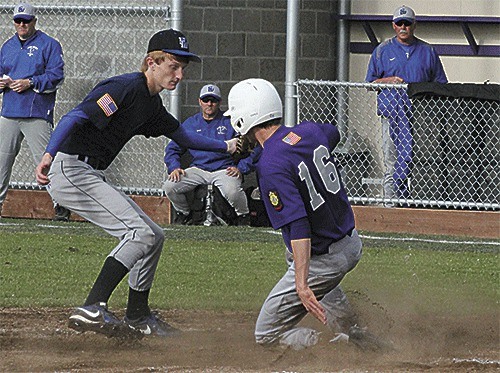 Oak Harbor's Teddy Peterschmidt scored on a wild pitch as South Whidbey's Colton Sterba applies the tag too late.