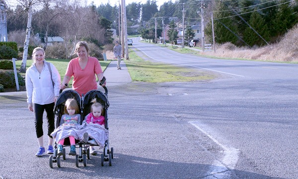 Andrea Horner and Deborah Wallin push little Ella and Emma on Northeast  Seventh Avenue Thursday afternoon. They said walking on the road can feel dangerous because of the lack of sidewalks in some places.