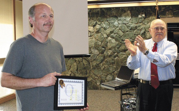 Custodian Ron Dunphy accepts an award from the Oak Harbor School District Monday for saving the life of an 8-year-old boy.