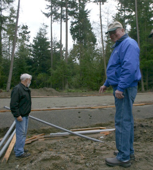 Pete Berg and Richard Johnson point out the water system installed by Johnson and Maurice Aasland at the site of the new Nordic Lodge on Jacobs Road in Coupeville.