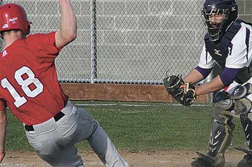 Oak Harbor catcher Danny Wolfe attempts to tag out Marysville-Pilchuck's Alex Gray at home plate  Wednesday.