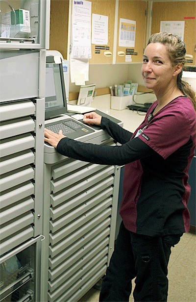 Whidbey General Hospital pharmacy technician Cherie Post dispenses medication from a new automated machine from Omnicell.
