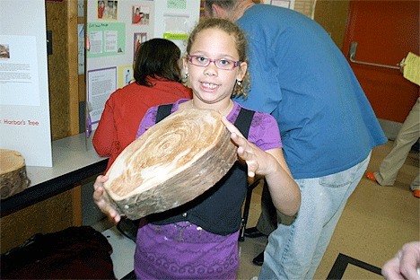 Crescent Harbor Elementary School third-grader Makayla Jenkins displays a chunk of wood she used in her experiment about tree growth