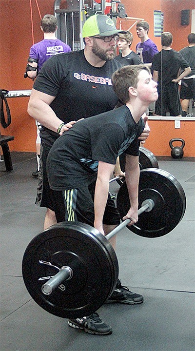 Kyle Isaacson helps Dylan Bailey with his lifting technique at a recent off-season workout.
