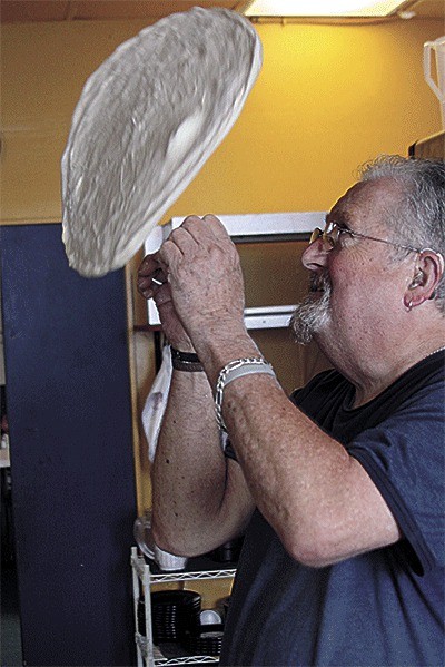 John Youngsman Sr. puts on a dough-tossing display in the kitchen of Louie-G’s Pizza in Oak Harbor.
