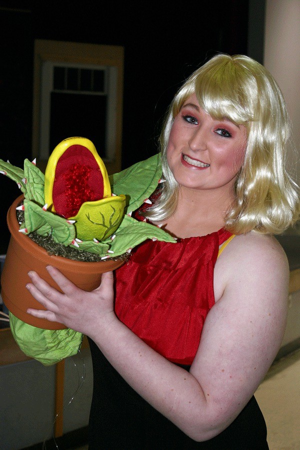 Senior Carly Kessler holds up the flesh-eating monster when it’s little more than a seedling before a music rehearsal for the “Little Shop of Horrors” last week.