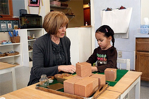 Garden Isle Montessori teacher Darrellyn Currier helps Malena Nealon with an assignment recently. Twenty-five students spend their first years of elementary school attending classes at the venerable school located near Coupeville’s historic downtown.