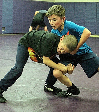 Dylan Estes and Tevor Lang (blue shirt) work during a drill at a recent Whidbey Wildcat Wrestling Club practice.