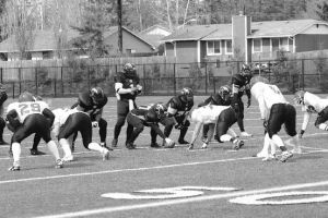 Skagit Valley Lightning quarterback Brad Collins checks the play on his wristband before setting the team in Saturday’s Evergreen Football League game against the Tri-City Knights at Wildcat Memorial Stadium. The Lightning will play the Wenatchee Valley Rams April 26 in Oak Harbor.