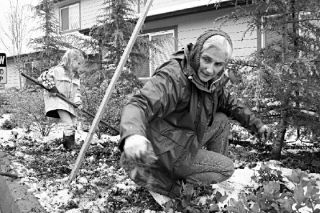 Cherry Dennis rids the ground around Marjie’s House of weeds during a recent series of projects undertaken by volunteers from Oak Harbor’s First Reformed Church. Mini-helper Heidi VanDyk helps with raking duties in the background.