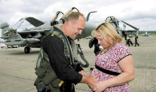 LEFT: Lt. Cmdr. Matt Kaslik gives his his wife Julie and their expected twin daughters a loving caress on June 2 as he arrives home to Whidbey Island Naval Air Station with the VAQ-135 “Black Ravens.” The squadron was part of the WESTPAC deployment that began in January on board the USS Nimitz. ABOVE: Jonathon