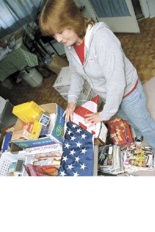 Cathy Caryl folds an American flag she received from a Marine in Iraq. Caryl has mailed nearly 400 packages to troops. The flag was flown in Iraq before the grateful Marine sent it to the longtime Island County employee.