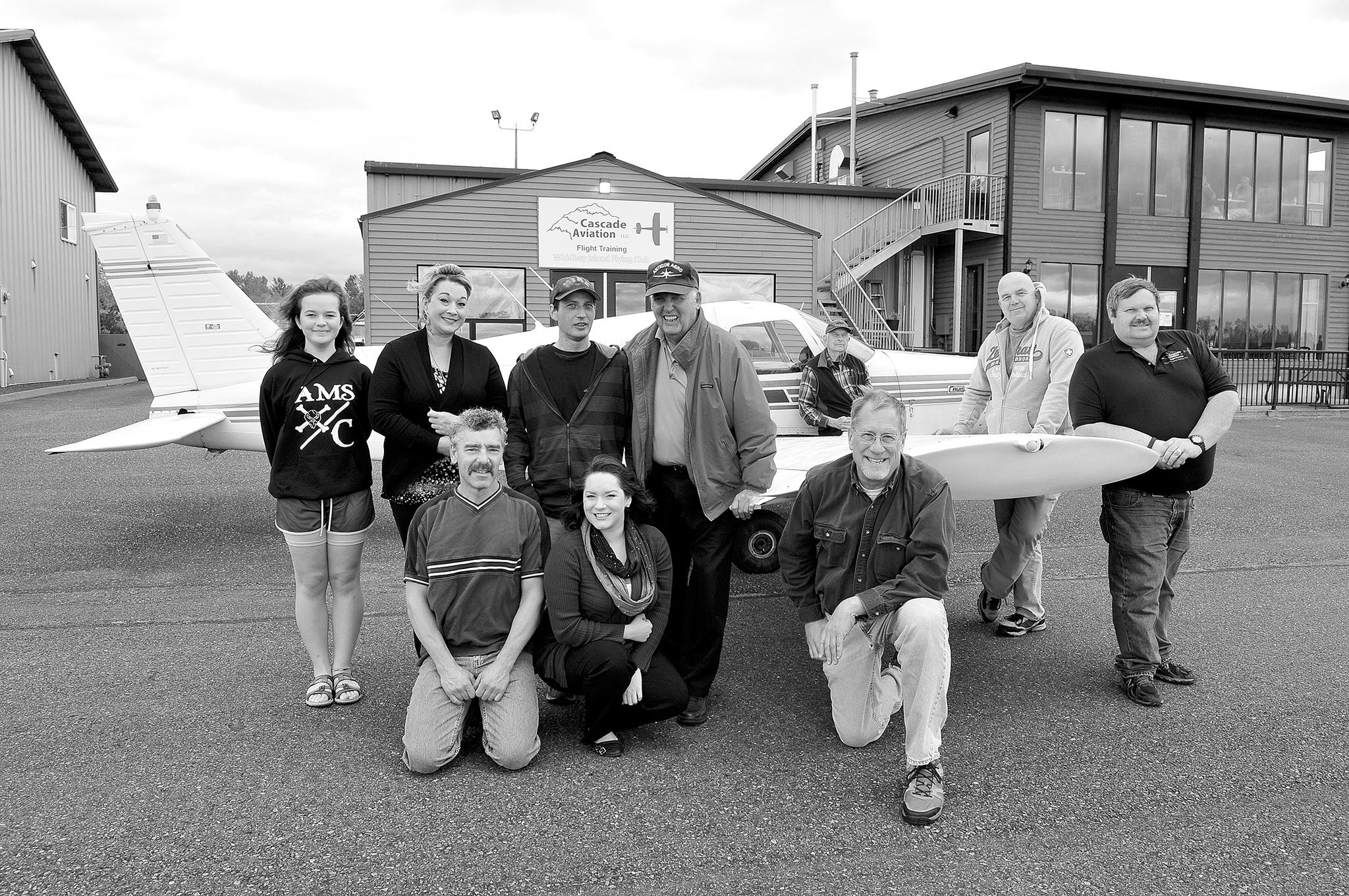 Photo by Michael Watkins/Whidbey News-Times                                Club members, owners and staff pose for a group photo in front of Cascade Aviation Saturday to celebrate its third year in business at the Skagit Regional Airport.