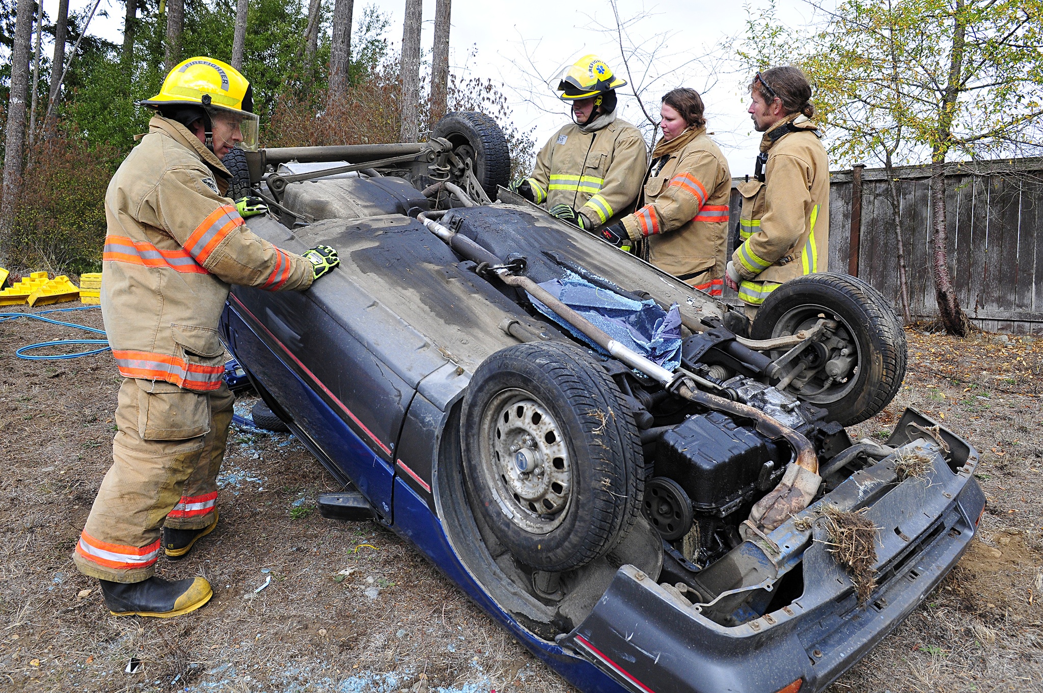 Photo by Michael Watkins/Whidbey News-Times                                Volunteer firefighters with North Whidbey Fire and Rescue station 25 work together to secure an overturned vehicle during a simulated rescue Saturday in Oak Harbor.