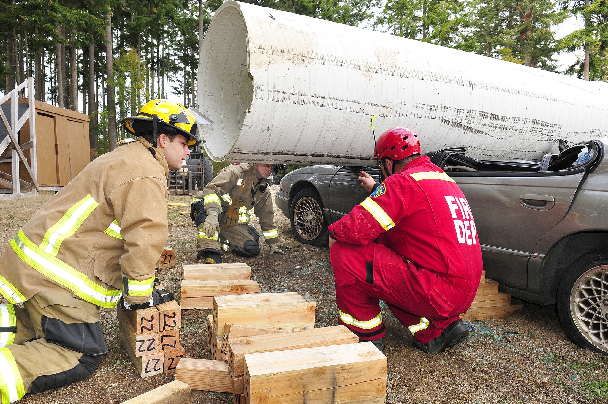 Michael Pelzer, left, Thomas Mohlsick center, and Ryan McCarthy, right, all volunteers of the North Whidbey Fire andRescue conduct extraction training Saturday in Oak Harbor. Photo by Michael Watkins/Whidbey News-Times