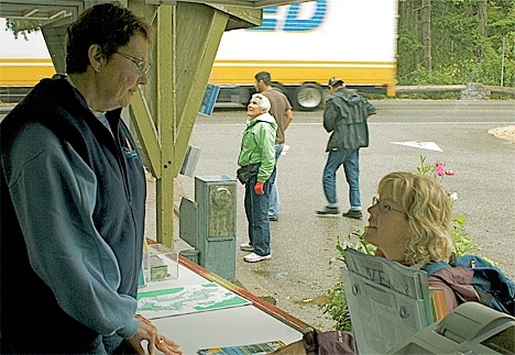 Judy Slager answers questions and offers advice to a tourist at the chamber’s WOW trailer at the Deception Pass Bridge.