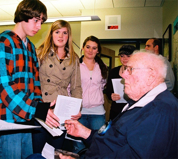 Lynn “Buck” Compton signs autographs for juniors at Coupeville High School Thursday. He visited the school to share his experiences of World War II.