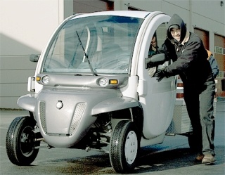 Jonathan Walle of Mather Auctioneers pushes an electric car into place Tuesday morning in preparation for the city-wide auction Saturday. Two electric cars will go up for auction