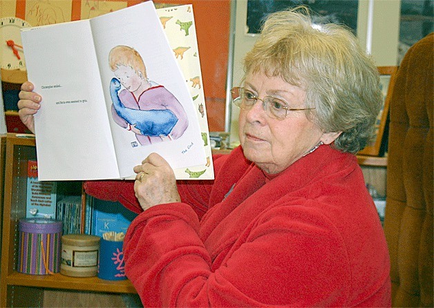 Oak Harbor author Penny Holland reads her newly released book “The Adoption of Boris” to a kindergarten class. She shows the paintings her mother-in-law