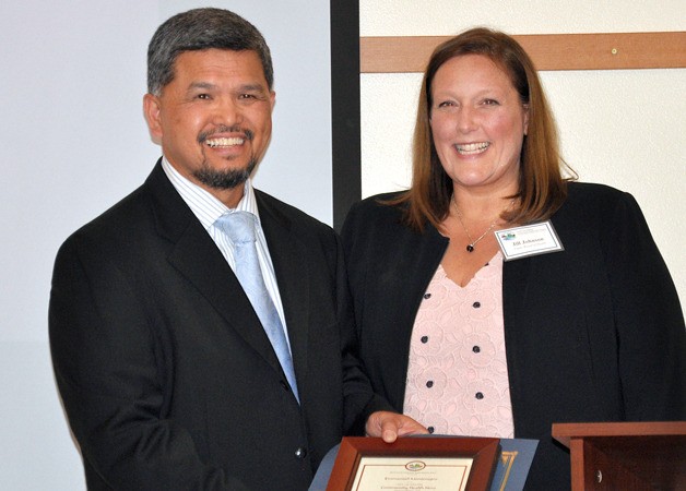 Island County Commissioner Jill Johnson presents a Linda Lee Martens Community Health Hero award to Emmanuel Montenegro