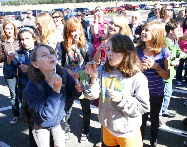 HomeConnection students celebrate the grand opening of their new school by blowing bubbles and sharing in chocolate cake and cookies at the ribbon cutting ceremony on Thursday
