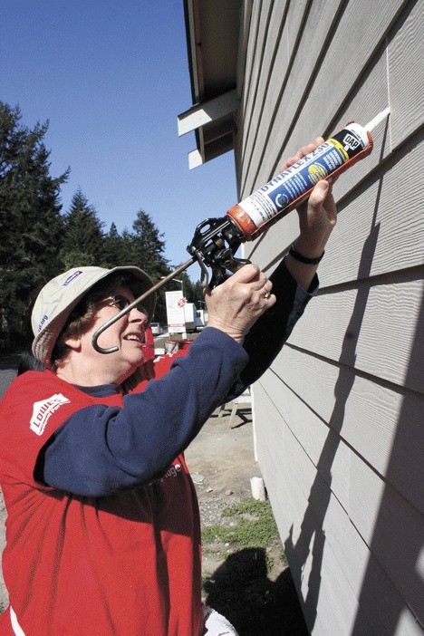 Michele Johnson applies caulk during the Women Build event taking place this Mother’s Day weekend. It’s sponsored by Habitat for Humanity of Island County.
