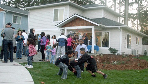 Cameron Asinsin and friends enjoy the Asinsins’ new yard as friends congratulate the family on their new home built by Habitat for Humanity volunteers.