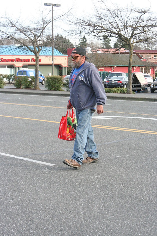 Richard Anderson crosses Whidbey Avenue between Saar’s Marketplace and the Roller Barn Thursday. Anderson said he needs to cross the street every day to get to the bus stop and the nearby stores. Though a necessity
