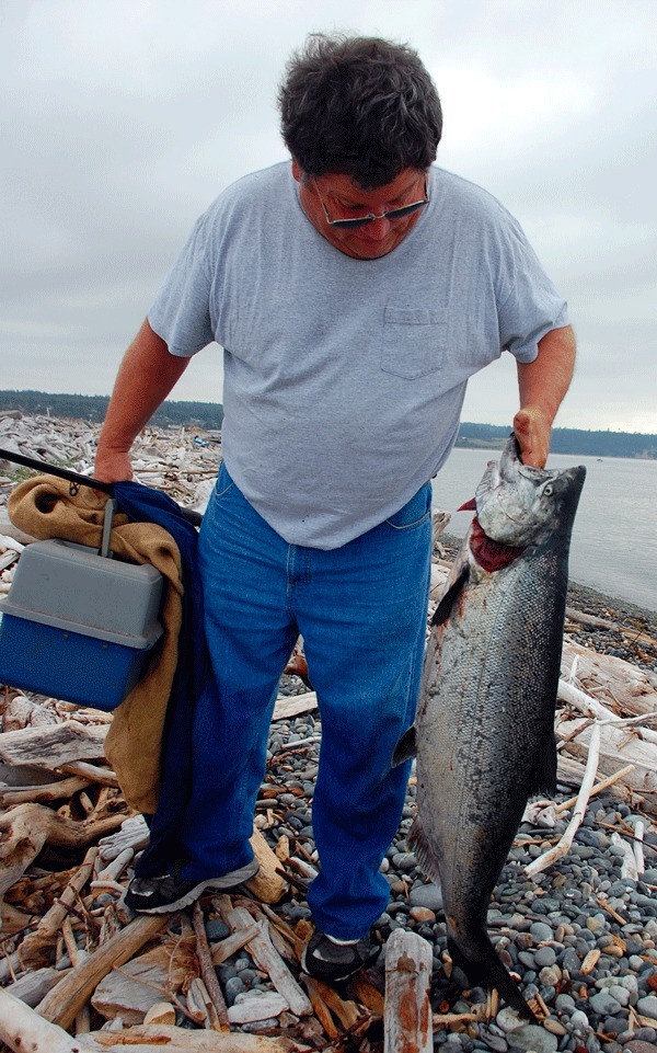 Coupeville resident Joe Biller hoists up the 28-pound salmon caught by Dan Dodds