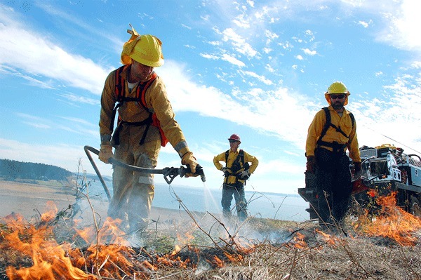 A burn controller with The Nature Conservancy keeps track of wandering flames under the watchful eyes of burn boss Peter Dunwiddie