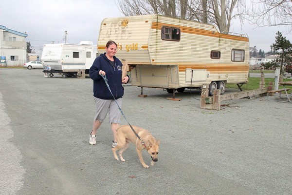 A woman walks her dog in the city’s RV park