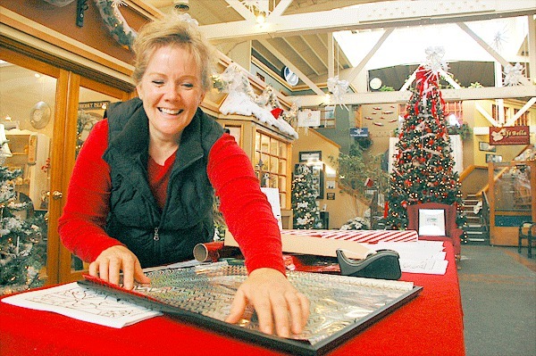 Downtown merchant Kristi Jensen prepares for a month of holiday festivities in downtown Oak Harbor. Things kickoff this weekend with the annual tree lighting on Pioneer Way.