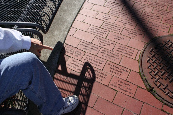 Dick Johnson points at the four paving bricks listing his familymembers.