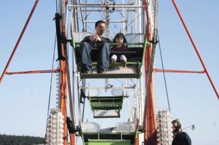 Shane Leavitt and his daughter Amber take a spin on the ferris wheel Thursday during Oak Harbor’s spring carnival. The Holland Happening festival will continue through Sunday.