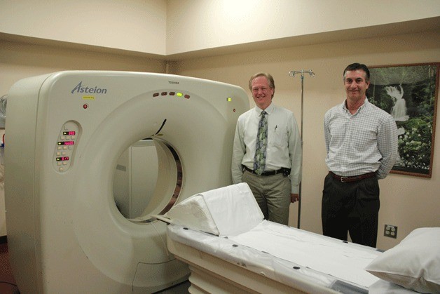 Chief Radiologist Dr. Robert Hawkins and Diagnostic Imaging Manager Randy White stand with Whidbey General Hospital’s old CAT scan machine. The medical providers said they are excited about the new CAT scan that will become operational as early as late December. The new machine will increase patient comfort