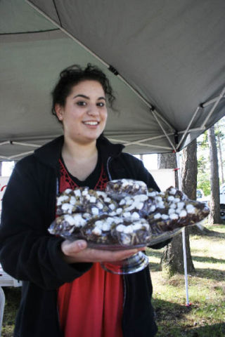 Oak Harbor High School graduate Arianna O’Dell awaits customers at the Oak Harbor Public Market. She decided to sell baked goods this summer as a way to make money and to learn about starting and operating a small business.