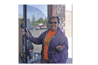 Pastor Fannie Dean inspects a broken window on her Oak Harbor Thrift Store