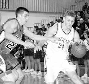Oak Harbor’s Grant Bull (No. 24) drives in the first half against Monroe. Bull led the Wildcats with 11 points in their 71-44 loss to the Bearcats on Thursday night.