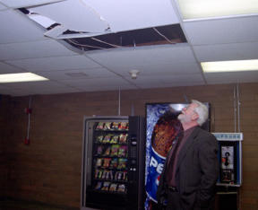 Oak Harbor High School principal Dick Devlin surveys a missing ceiling tile in the foyer of the old gym