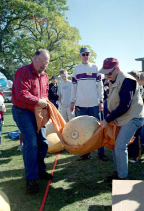 Jim Engstrom and Bob Wilson struggle to lift a 130-pound pumpkin onto the scales in Coupeville Saturday. But this was small potatoes compare to the 472-pounder grown by Lee Roof