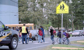 Students from Olympic View Elementary funnel out a gate on the playground after school and cross Regatta Drive to Fifth Ave. The city is requiring the school district to build sidewalks the length of the school grounds