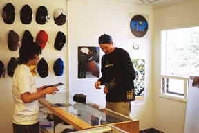 Matt Moss /Staff PhotoLocal skateboarder Mike Ratigan (right) tries on new wrist guards at Gizmo’s Boardshop on Midway Boulevard while shop owner Terrill Simecki looks on.